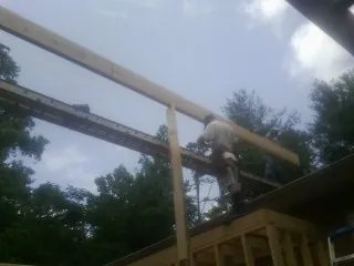Carpenter setting a ridge beam over a new addition frame — Ice Dam Removal by Roofing Brothers in Orangevale